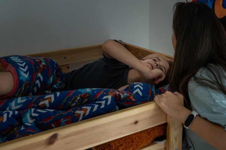 Caring mother gently wakes her sleepy young child